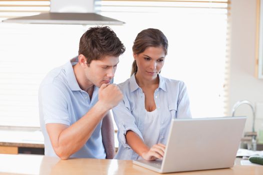 Couple using a laptop in their kitchen