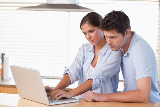 Couple using a notebook in their kitchen