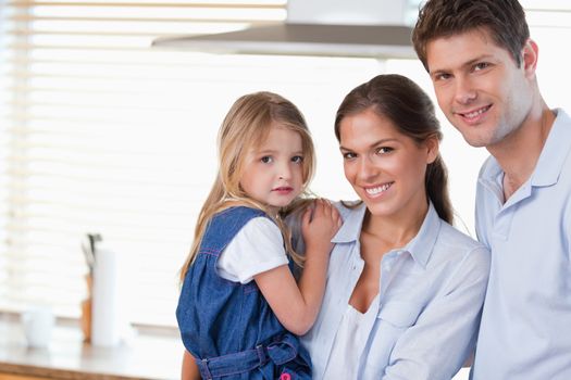 Young family posing in their kitchen