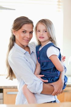 Portrait of a mother and her daughter posing in their kitchen