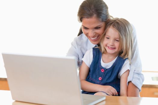 Mother and her daughter using a notebook in their kitchen