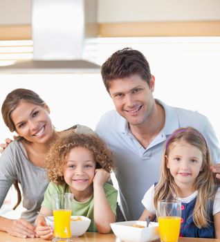 Smiling family having breakfast in their kitchen