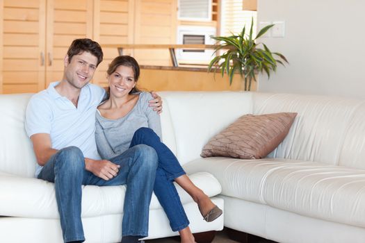 Couple sitting on a sofa while looking at the camera