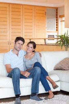 Portrait of a couple sitting on a couch while looking at the camera