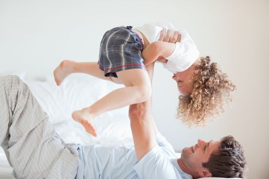 Side view of smiling father lifting his child