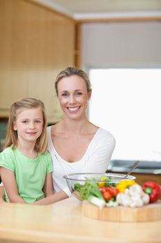 Smiling mother and daughter in the kitchen together