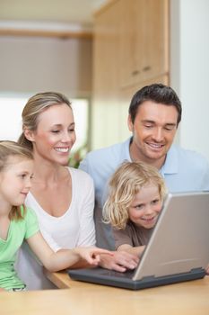 Family using laptop in the kitchen together