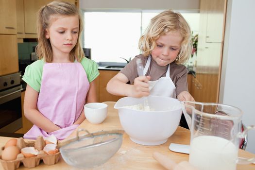 Young siblings preparing dough together