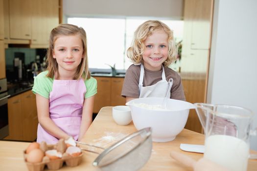 Smiling siblings preparing dough together