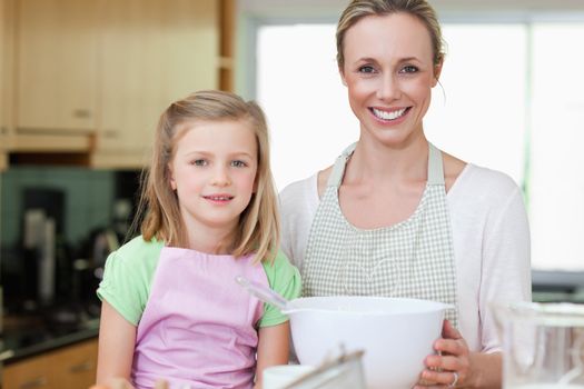 Mother and daughter together with bowl in the kitchen