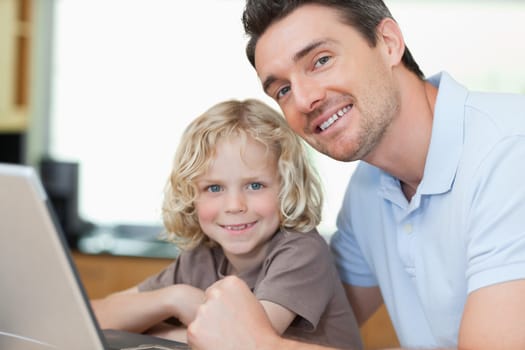Smiling father and son together with notebook