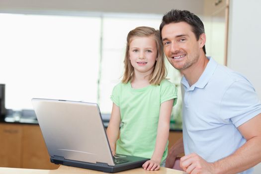 Father and daughter using laptop together