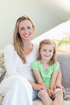 Mother and daughter sitting on the sofa together