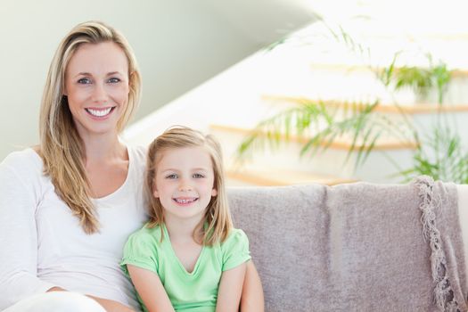 Mother and daughter sitting on the couch together