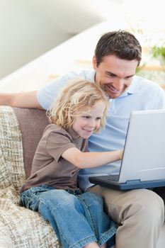 Father and son together with notebook on sofa