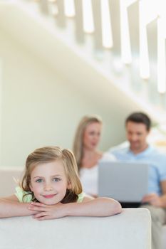 Smiling little girl with her parents behind her