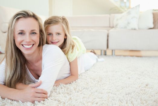 Mother and daughter lying on the floor together