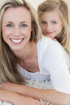 Happy mother and daughter together on the floor