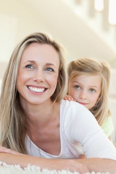 Smiling mother and daughter together on the floor
