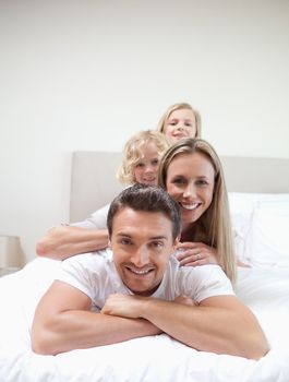 Family lying on each other on the bed