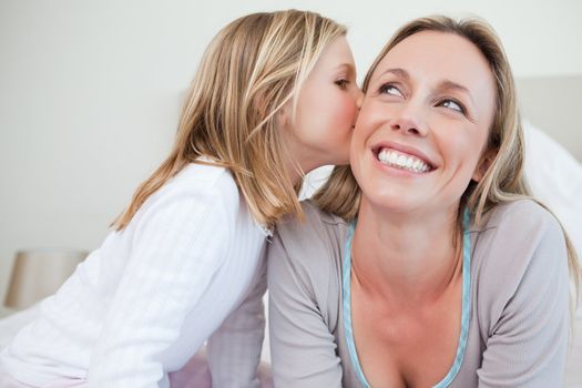 Little girl giving her mother a kiss
