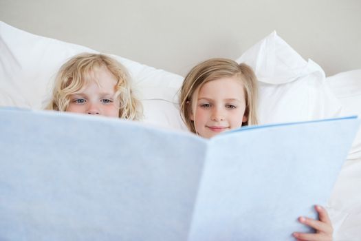 Siblings reading bedtime story together
