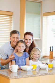 Smiling family with their breakfast in the kitchen