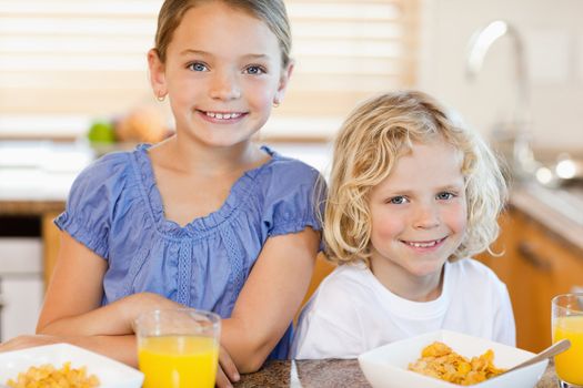 Brother and sister together with breakfast in the kitchen