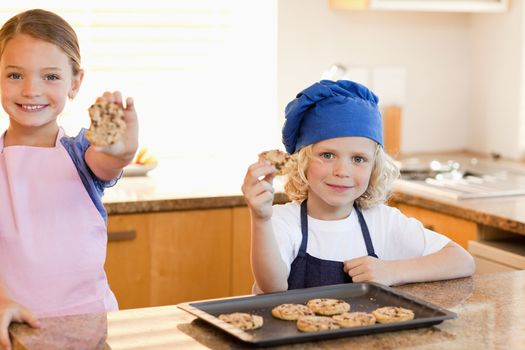Siblings holding their cookies up