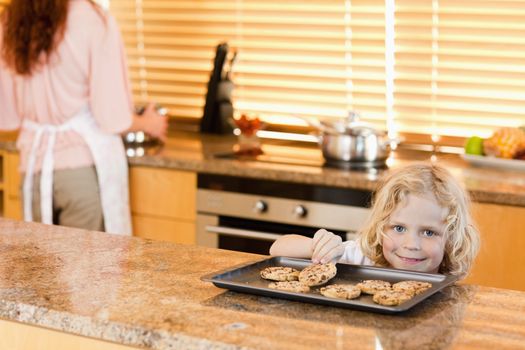 boy stealing a cookie while is mother is not watching
