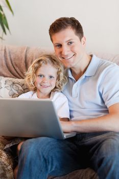 Father and son using laptop on the sofa
