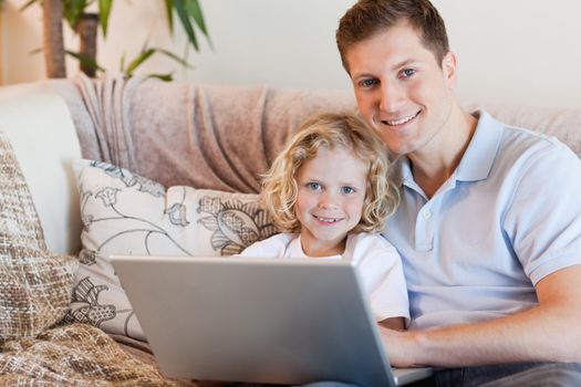 Father and son using notebook on the sofa