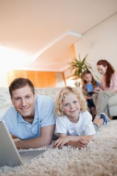 Father and son using the internet together on the floor