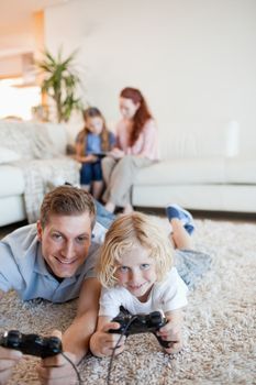 Father and son enjoying video games together in the living room