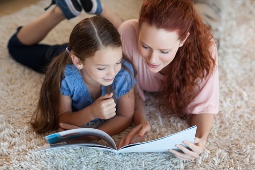 Mother and daughter on the carpet reading together