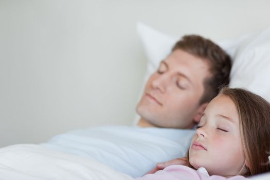 Side view of father and daughter asleep together