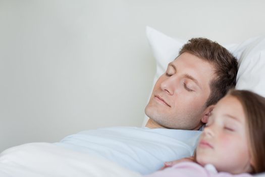 Father and daughter taking a nap next to each other