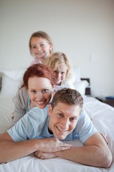 Playful young family together on the bed