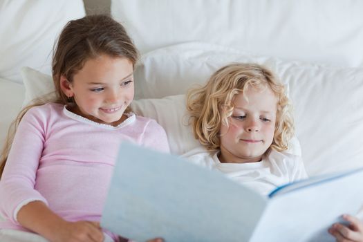 Brother and sister reading bed time story together