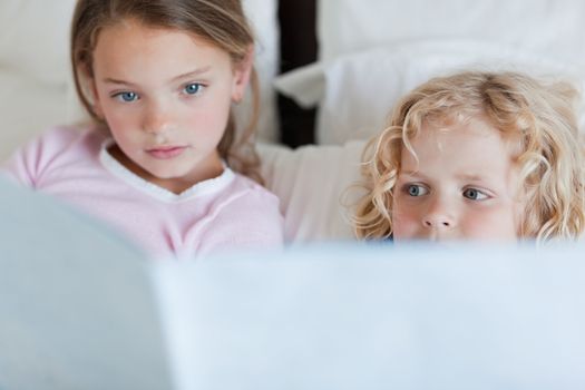 Siblings reading bed time story together