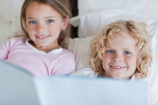 Siblings enjoy reading bed time story together