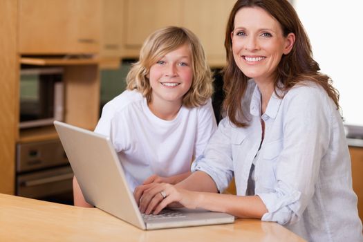 Mother and son with laptop in the kitchen