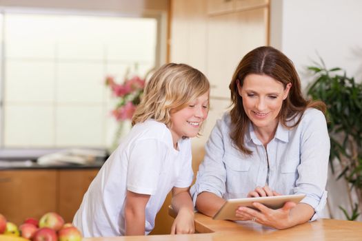 Woman and son using tablet in the kitchen together