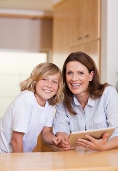 Woman and her son using tablet in the kitchen together