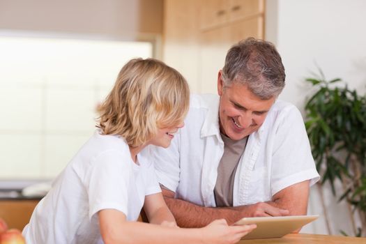 Father and son using tablet together