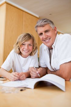 Boy getting help with his homework from father