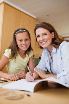 Mother helping her daughter with homework