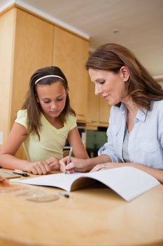 Woman helping her daughter with homework