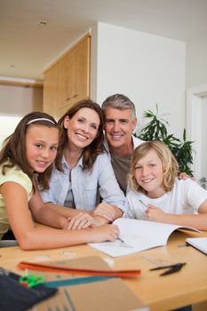 Smiling family doing homework together