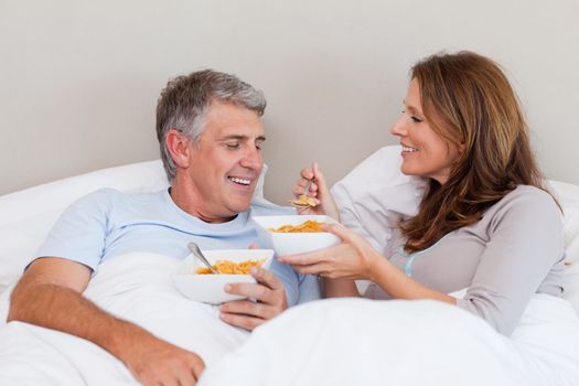 Mature couple having breakfast in their bed